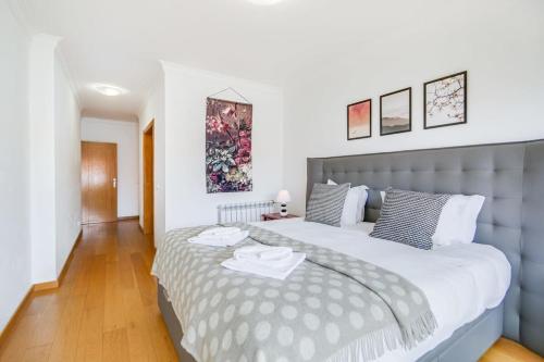 um quarto com uma cama grande num quarto em Admiral House Estoril em Estoril