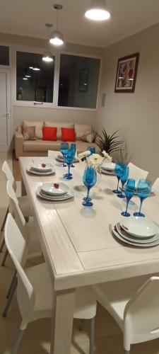 un tavolo bianco con sedie e bicchieri blu sopra di LOS NARANJOS a Reconquista