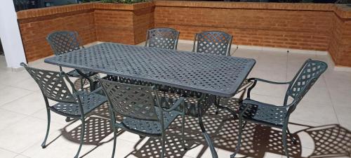 une table en métal et des chaises assises sur une terrasse dans l'établissement LOS NARANJOS, à Reconquista