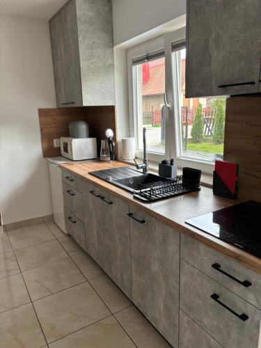 a kitchen with a sink and a counter top at Domek nad Dunajcem in Krościenko