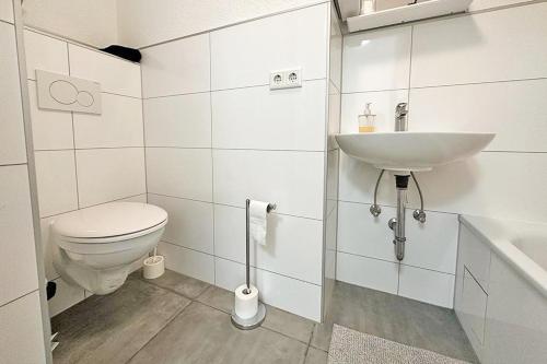 een witte badkamer met een toilet en een wastafel bij Air Apartments 13 in Bremen
