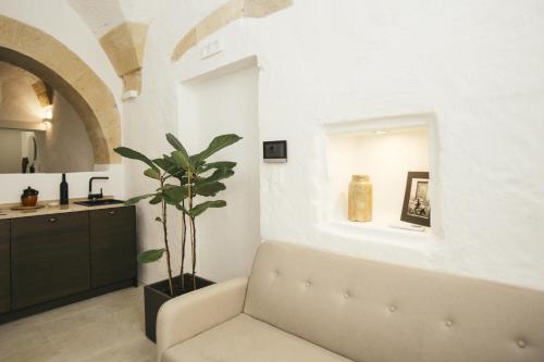 a living room with a couch and a plant at Mediterranee Suite in Lecce