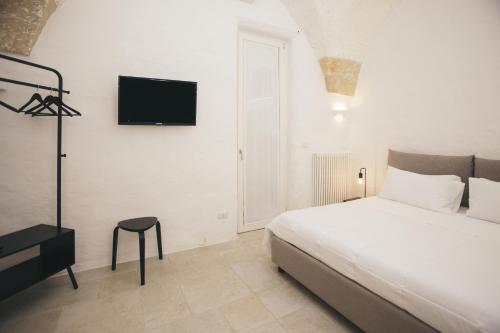 a bedroom with a bed and a television on the wall at Mediterranee Suite in Lecce