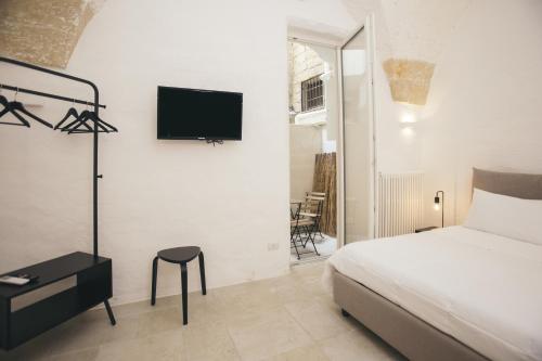 a bedroom with a bed and a tv on a wall at Mediterranee Suite in Lecce