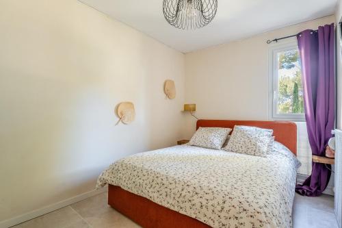 1 dormitorio con 1 cama y una ventana con cortinas moradas en La Saltarelle par Dodo à Cassis, en Cassis