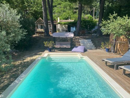 - une piscine dans un jardin avec une table et une chaise dans l'établissement Magnifique villa toute climatisée, à Éguilles