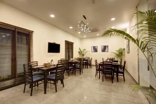 una sala da pranzo con tavoli e sedie in legno di Saltstayz Thyme - New Friends Colony a Nuova Delhi