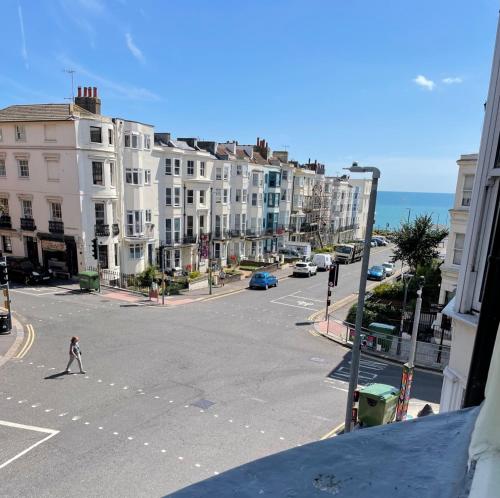 a person crossing a street in a city with buildings at Upper Rock Brighton Apartments in Brighton & Hove