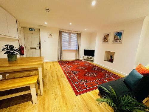a living room with a couch and a red rug at Upper Rock Brighton Apartments in Brighton & Hove