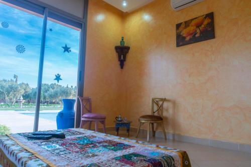 1 dormitorio con cama y ventana grande en Villa Marrackech Sbai en Oubadine