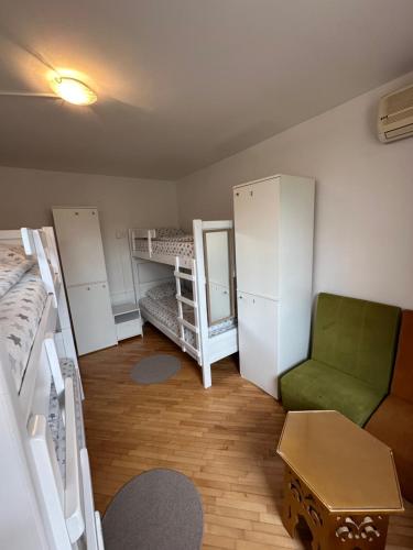 a room with two bunk beds and a green chair at One Love in Sarajevo
