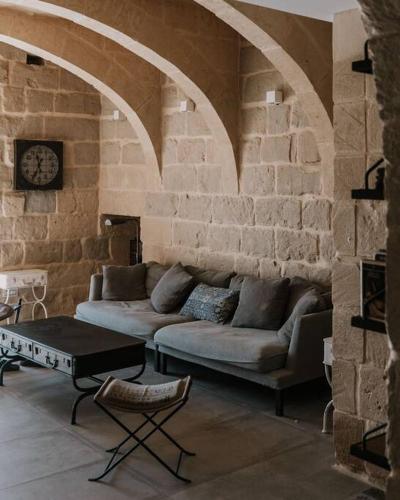 a living room with a couch and a table at Blissful 4-bedroom villa with pool in Għasri