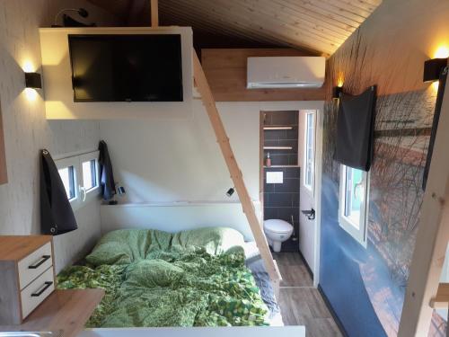 um pequeno quarto com uma cama numa pequena casa em Tiny Haus Blanker Hans auf dem Campingplatz Strandgut em Cuxhaven
