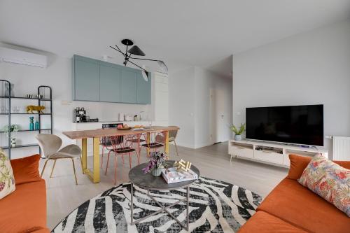 a living room with a couch and a table and a tv at Scala City Center Premium Apartments with Parking by Lion Apartments in Gdańsk