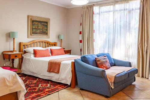 a bedroom with a bed and a chair and a bed at Waters on Willows in Pretoria