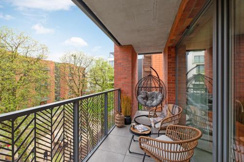 a balcony with two chairs and a bird cage at Scala City Center Premium Apartments with Parking by Lion Apartments in Gdańsk