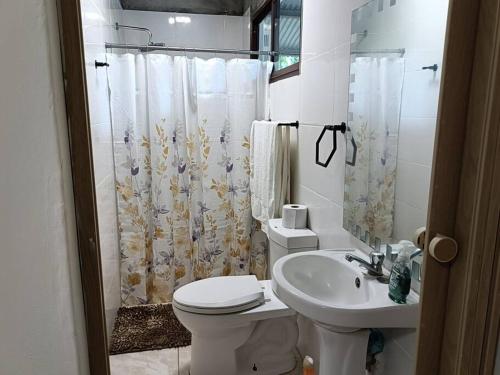 een witte badkamer met een toilet en een wastafel bij La Amistad agrotourism farm in Penonomé