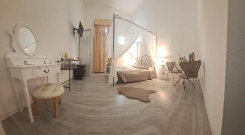 a bedroom with a bed and a vanity and a mirror at Hotel Antico Borgo in Riolo Terme