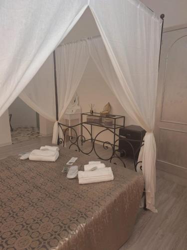 a bedroom with a bed and a table with towels on it at Hotel Antico Borgo in Riolo Terme
