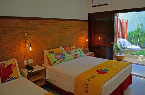 a bedroom with a bed and a brick wall at Hotel Village Porto De Galinhas in Porto De Galinhas