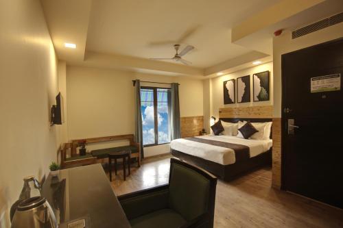 a bedroom with a bed and a desk and a piano at Saltstayz Thyme - New Friends Colony in New Delhi