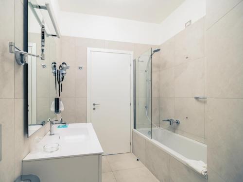 a bathroom with a shower and a sink and a tub at Hotel Mercure Milano Solari in Milan