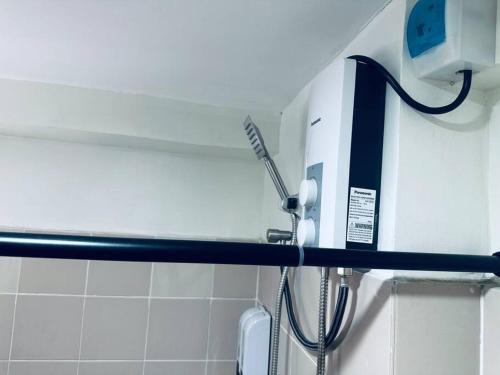 a shower head and a hair dryer in a bathroom at Mactan Oasis Garden/ 2 Bedrooms/ Near Airport in Mactan