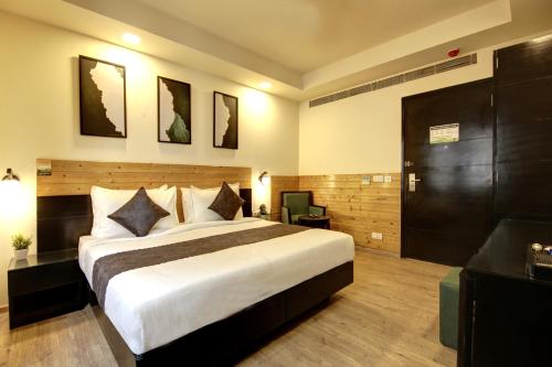 a hotel room with a large bed and a desk at Saltstayz Thyme - New Friends Colony in New Delhi