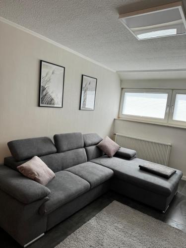 a living room with a couch and two windows at Ferienwohnung Maas in Ueß