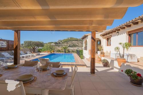 a patio with a table and chairs and a swimming pool at CostaBlancaDreams Casa Narciso in Calpe in Empedrola