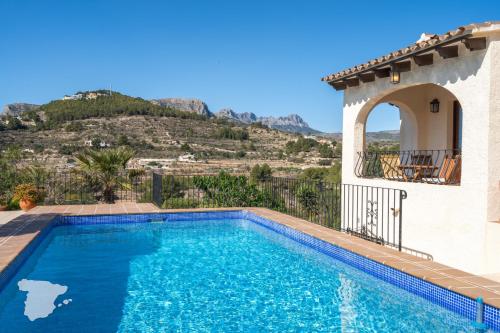 a swimming pool in front of a house with a mountain at CostaBlancaDreams Casa Narciso in Calpe in Empedrola