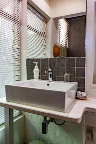 a white sink in a bathroom with a window at Waters on Willows in Pretoria