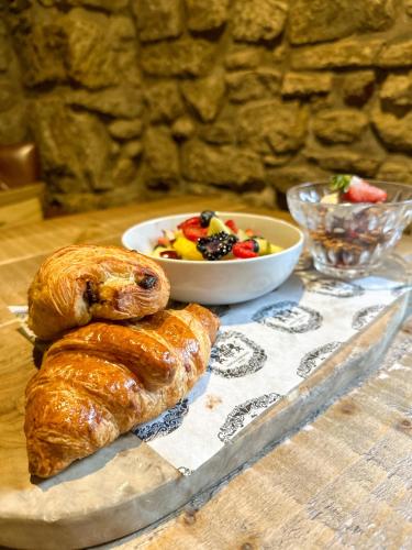 a table with two croissants and a bowl of fruit at The Northumberland Arms in West Thirston