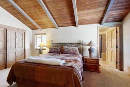 a bedroom with a large bed and wooden ceilings at Home in the Pines in Munds Park