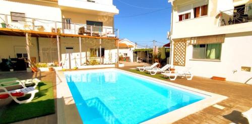 a villa with a swimming pool in front of a building at Seixal Bay Village - Estúdio Vista Piscina in Seixal