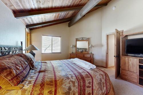 a bedroom with a bed and a flat screen tv at Home in the Pines in Munds Park