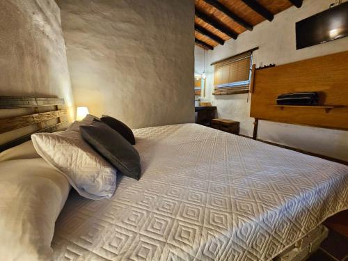 a bedroom with a bed with pillows on it at Cabañas y Hostal Bonanza mesa de los santos in Los Santos