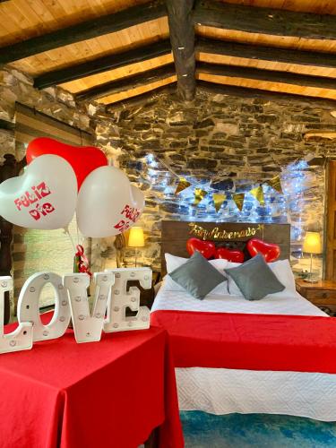 a bedroom with two beds and a red table with balloons at Cabañas y Hostal Bonanza mesa de los santos in Los Santos