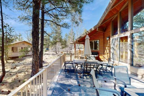 a porch of a log cabin with a table and chairs at Home in the Pines in Munds Park