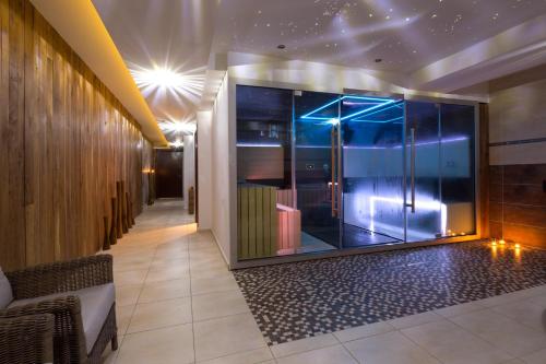 a lobby with a large glass wall with a shower at Pivovar Sandorf in Prievaly