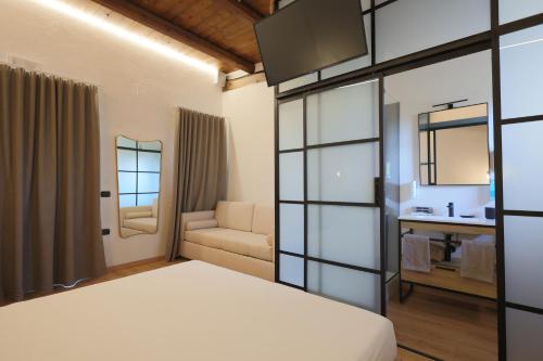 Schlafzimmer mit einem Bett, einem Waschbecken und einem Spiegel in der Unterkunft Valerio Resort beach club in Margherita di Savoia