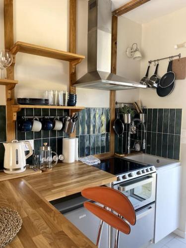- une cuisine avec un comptoir et une cuisinière four supérieur dans l'établissement Charmante Petite maisonnette, à Quiberon