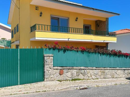 a green fence in front of a house at Villa dos castanheiros in Cascais