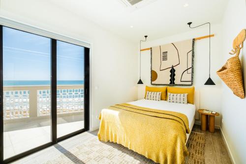 a bedroom with a bed with a view of the ocean at Casa na Muralha - Beach front - Rooftop Jacuzzi by DreamvillasAlbufeira in Albufeira