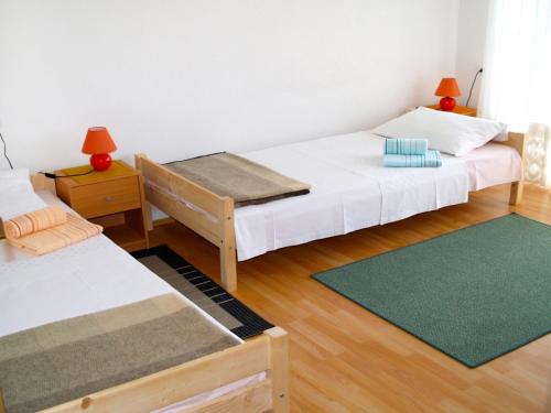 una camera con due letti e un tappeto verde di Apartment Marijana, Free Parking a Selce