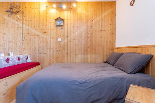 a bedroom with a bed in a wooden wall at Les Marmottes in Selonnet
