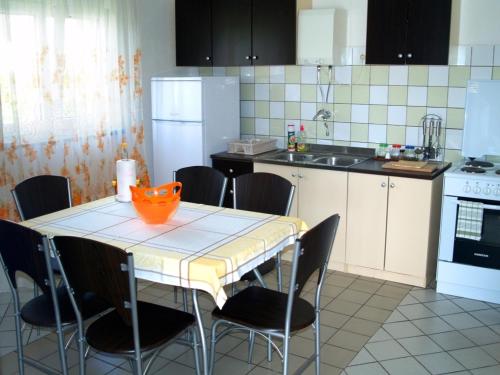 a kitchen with a table with chairs and a kitchen with white appliances at Apartment Marijana, Free Parking in Selce