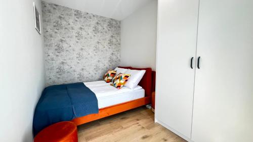 een kleine slaapkamer met een bed en een witte kast bij Prestige Apartments - Orłowska 40 in Gdynia