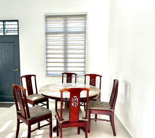 a dining room with a table and chairs at Homestay Rumi in Machang
