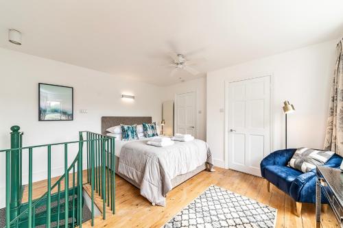 a bedroom with a bed and a blue couch at The Secret KENSINGTON Garden Mews-2 Bedroom FULL HOUSE-2 Train Lines- SPACIOUS-Kings Road- Harrods -Chelsea Stadium-PRIVATE small patio in London